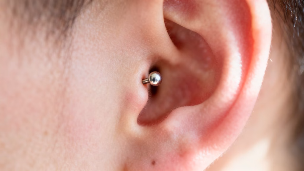 Close-up of a new ear piercing with a stud.