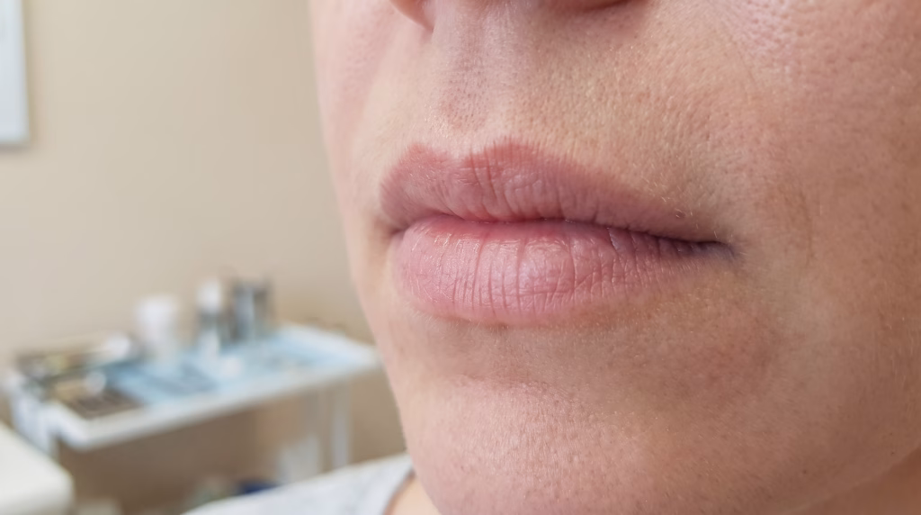 Close-up of bare natural lips at rest with no lipstick, at their own natural size